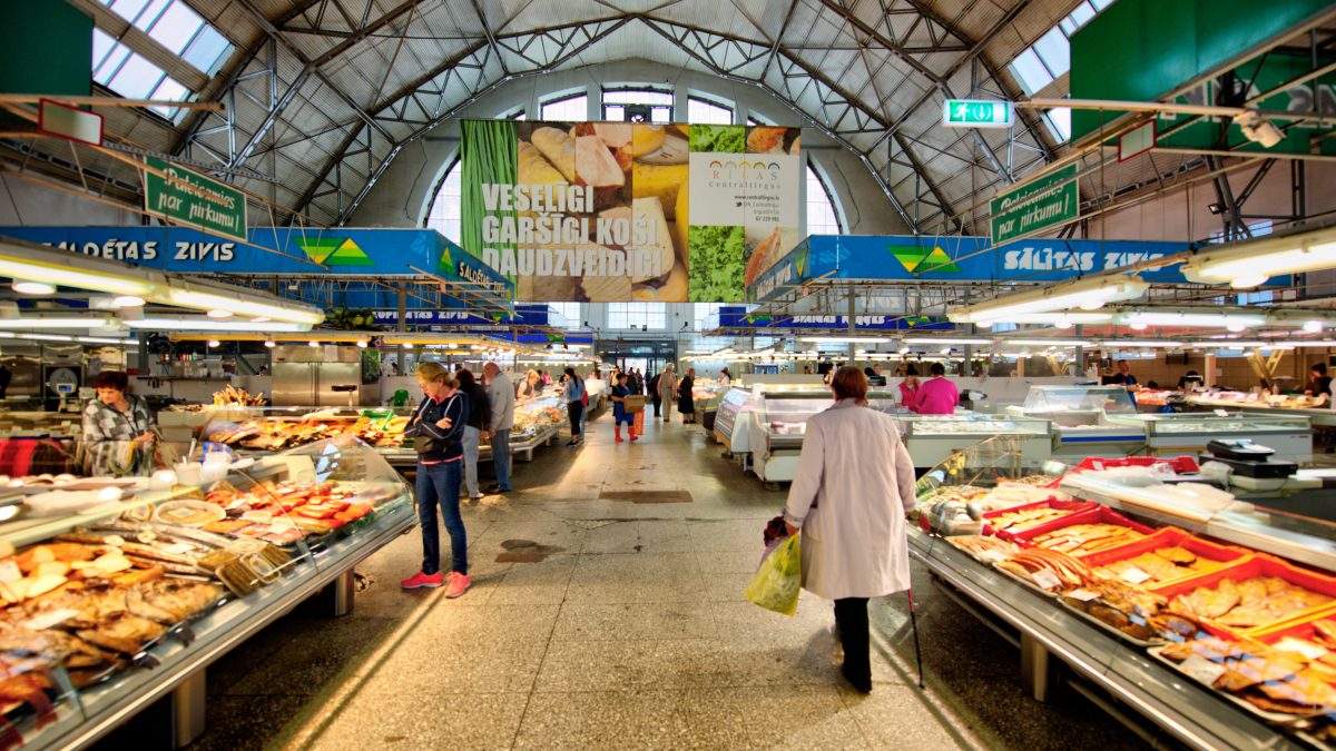 Colourful grocery store with customers walking in aisle